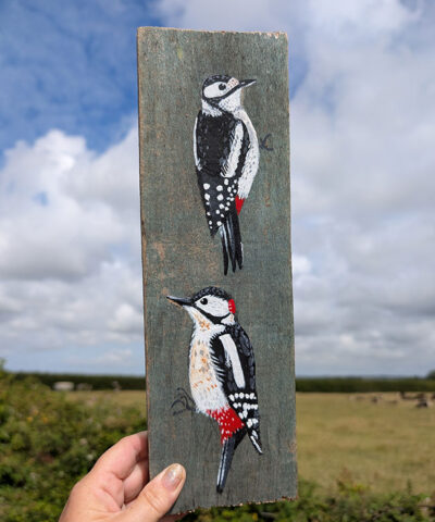 Ying and Yang. A pair of woodpeckers painted on The Isle of Colonsay wood